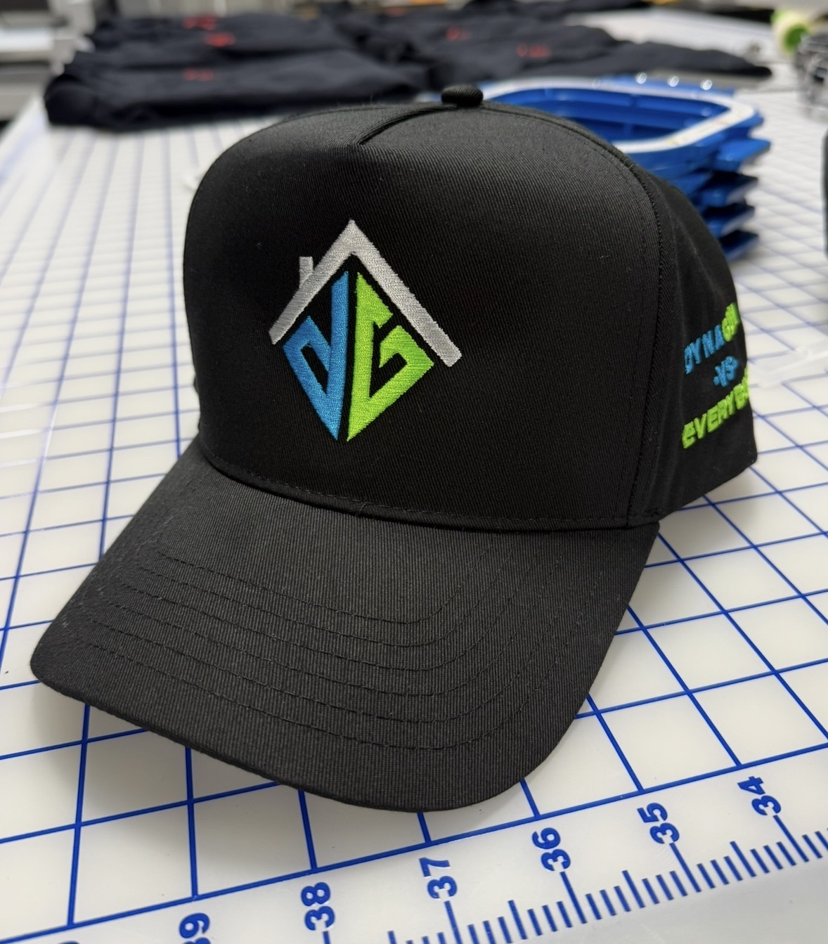 Black cap with blue, lime green and white embroidered house-shaped logo