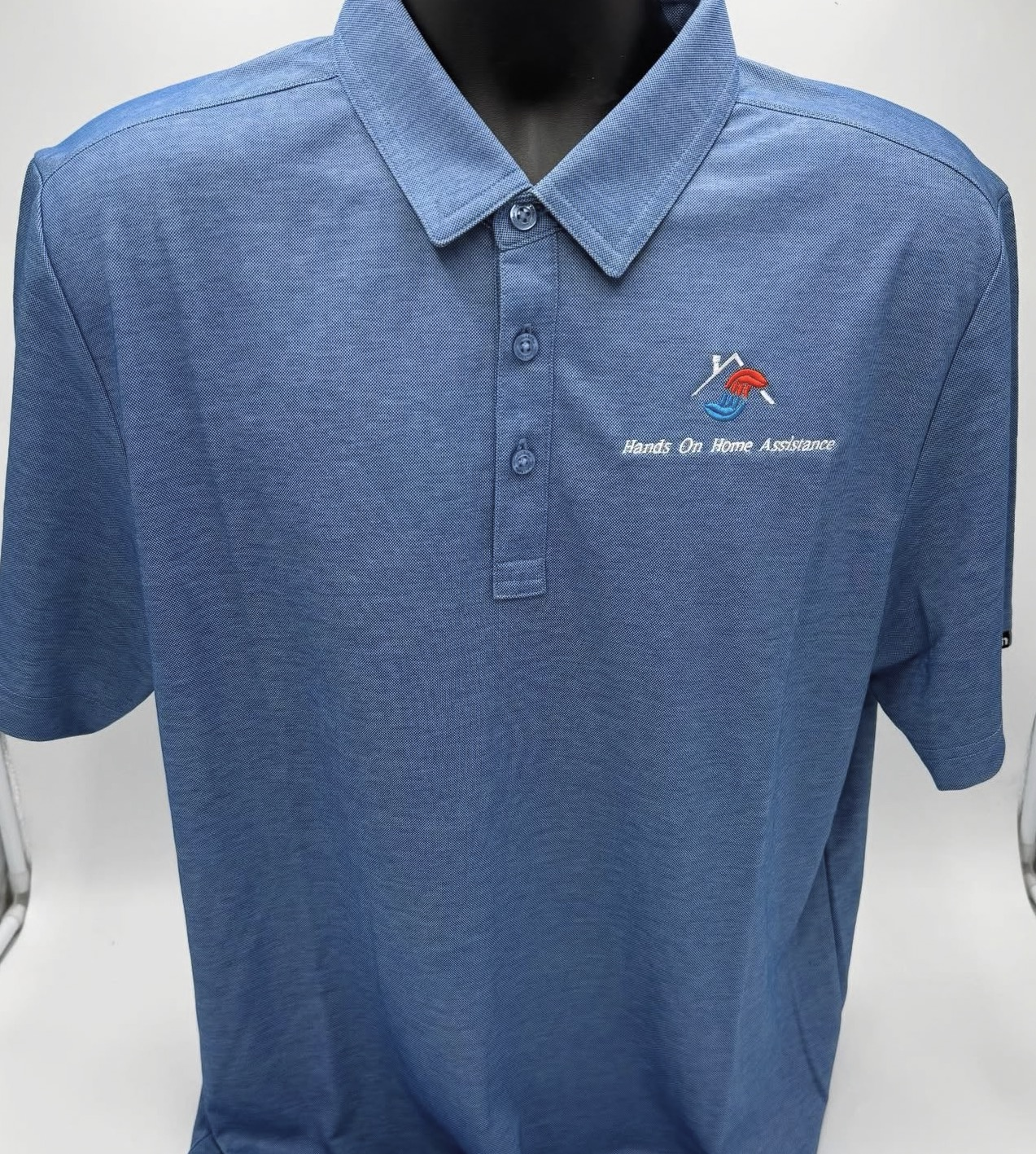 Blue polo with Hands On Home Assistance logo embroidered on the chest