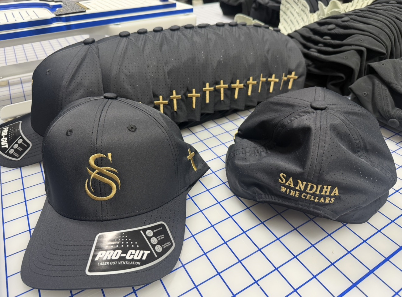 Black Sandiha Wine Cellars caps with gold monogram, lettering and cross embroidery