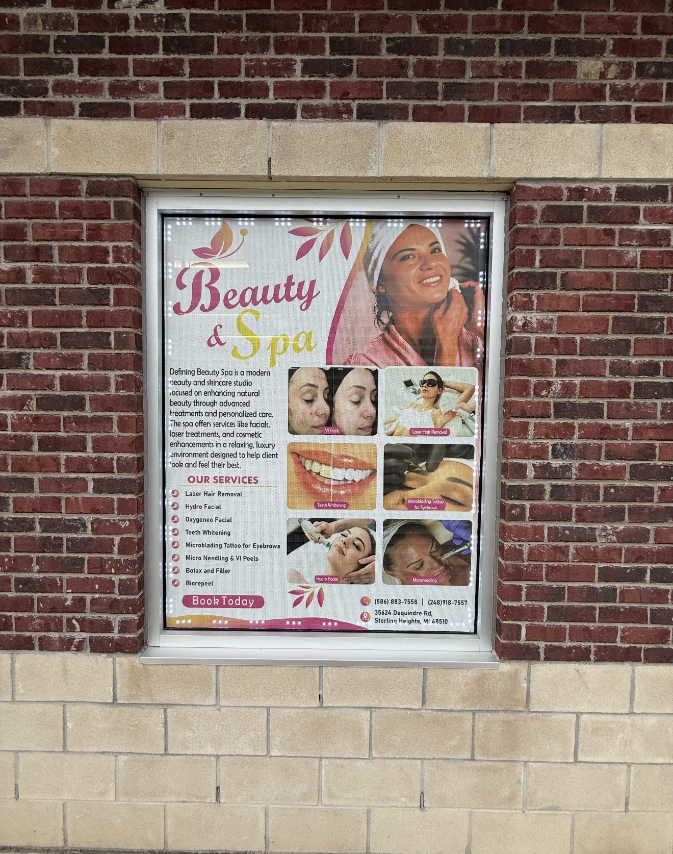 Full-color beauty and spa services window sign installed on a brick storefront